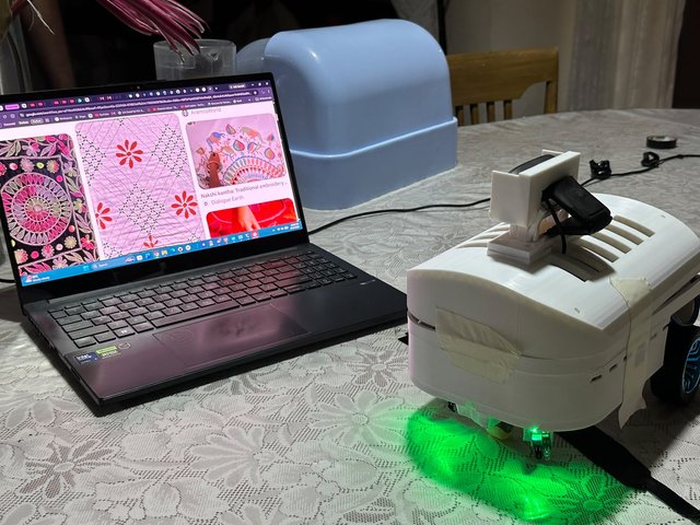 MuseBot AI parked next to a laptop showing its AI conversation pipeline running.