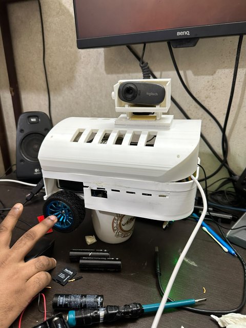 A hand adjusting one of MuseBot AI’s drive wheels during assembly.