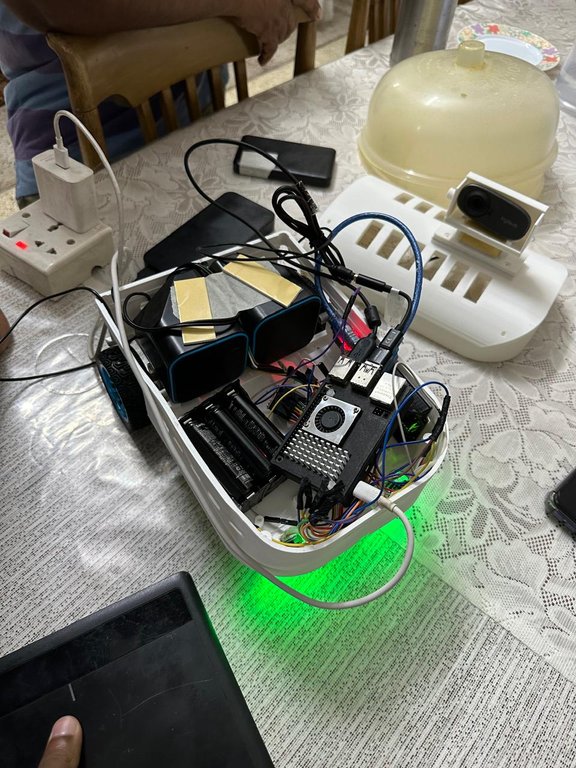 Open chassis of MuseBot AI showing the Arduino Uno, Raspberry Pi 4B, motor driver, and battery pack wired inside.